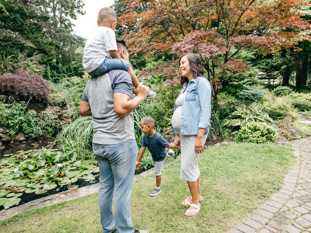 Pregnant woman smiling at her partner and two children