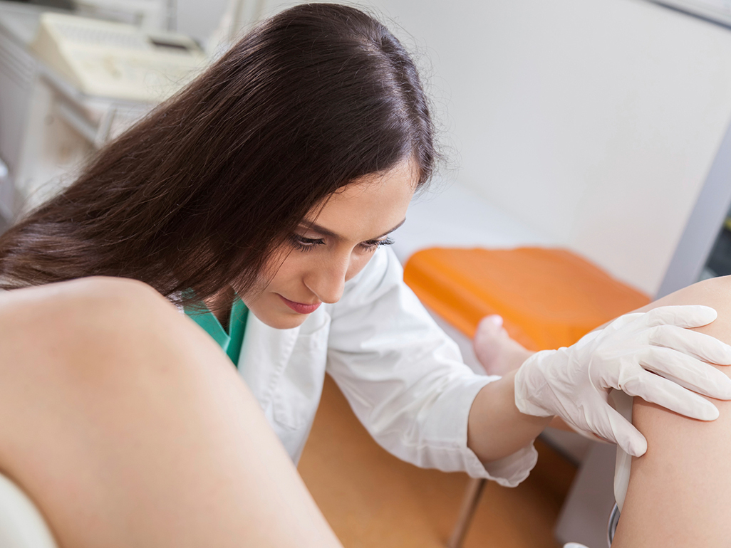 Doctor carrying out an internal exam on a woman in her clinic 