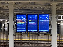 Three digital signs in a below-ground subway station. Left sign reads "Current status: Reduced service. Red line, orange line, green line, blue line. Saturday schedule". Center sign reads "Current status: Reduced service. Bus, silver line, commuter rail." Right sign reads: "Current status: No service. Ferry" All signs have a link at the bottom to MBTA.com/coronavirus