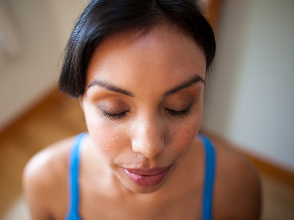 Woman with eyes closed focusing on breathing in preparation for doing Kegels