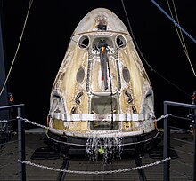 A space capsule with burnt marks on sea