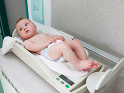 Baby lying on a weighing scale