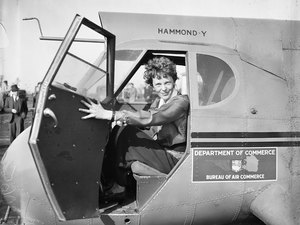 Amelia Earhart sitting inside a plane with it's door open