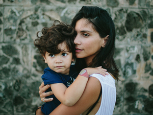 Mãe carrega criança no colo