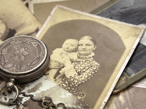 vintage pocket watch standing on rustic mum holding her baby photo