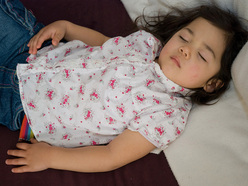 little girl asleep on bed