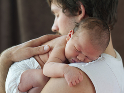 Dad holding newborn over his shoulder