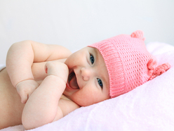 baby in a pink hat, laughing at the camera