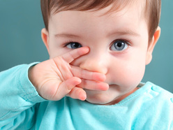 baby covering her nose and mouth with the back of her hand