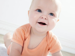 smiling baby in orange onesie