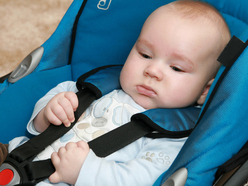 baby strapped into baby capsule