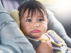 Toddler in carseat looking upset