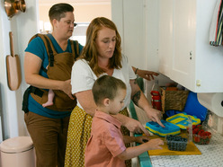 Young boy preparing his lunch with his parents