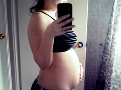 woman 20 weeks pregnant showing her belly