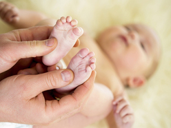 Parent massaging the soles of a baby's feet