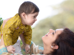 Smiling mum holding her baby up in the air