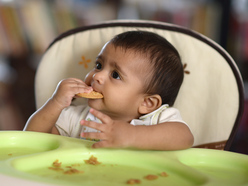 1 year old eating on high chair