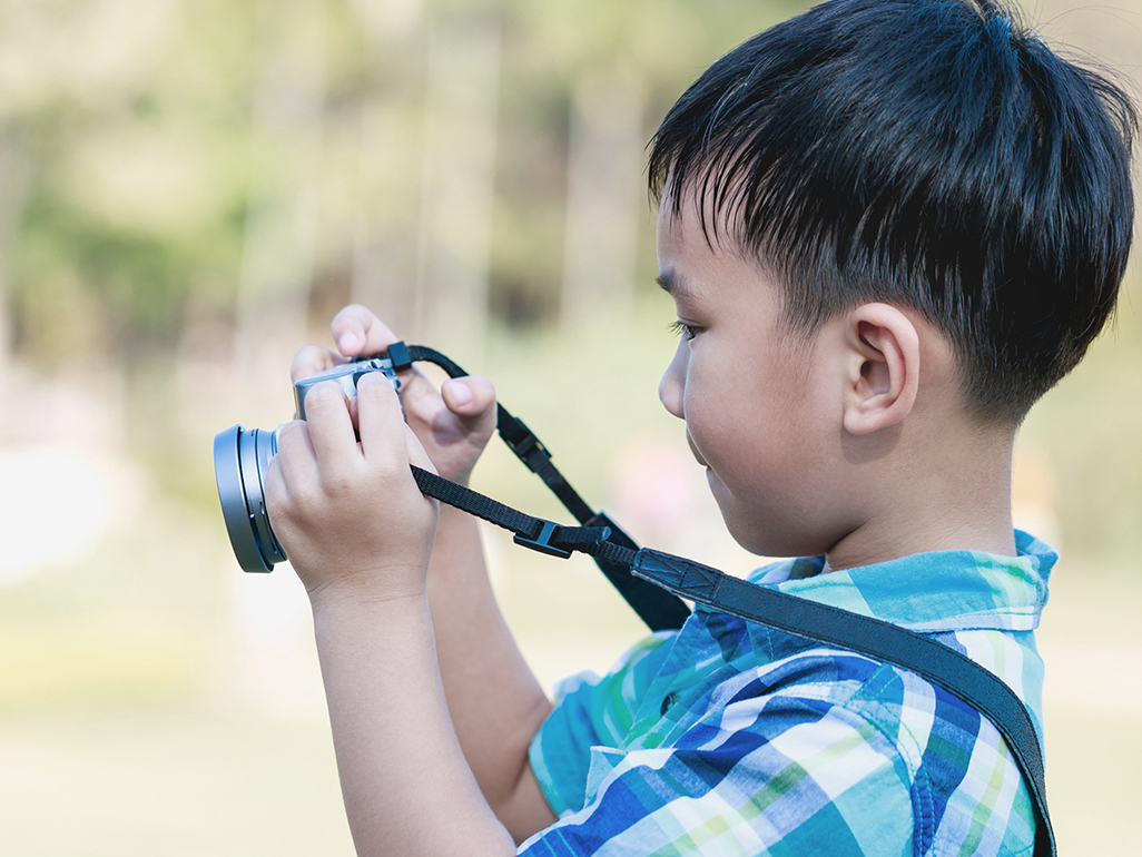 boy trying to take a photo with a digital camera