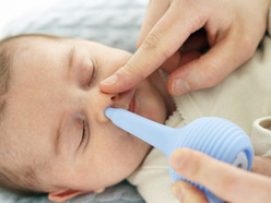 cleaning a baby's nose with a bulb syringe