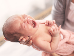 newborn crying in mom's arms