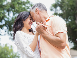 Older man and younger woman dancing outside