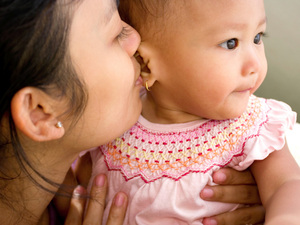 Mum whispering in her baby's ears