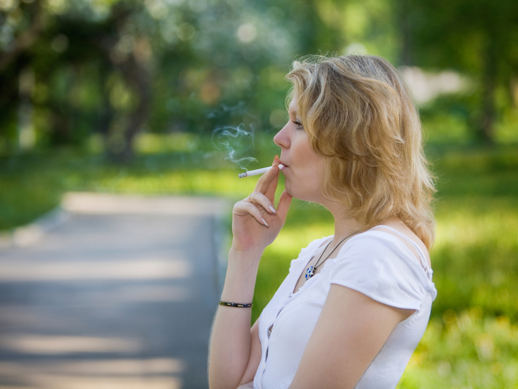 Woman smoking cigarette outside