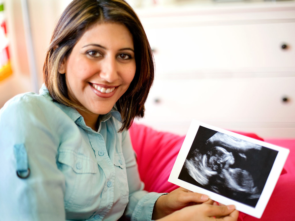 Pregnant woman looking at her ultrasound picture