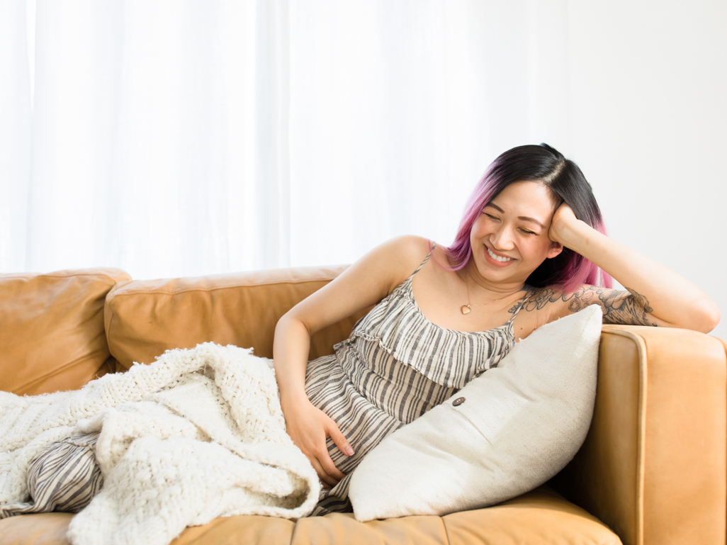 Pregnant woman smiling and relaxing on the couch