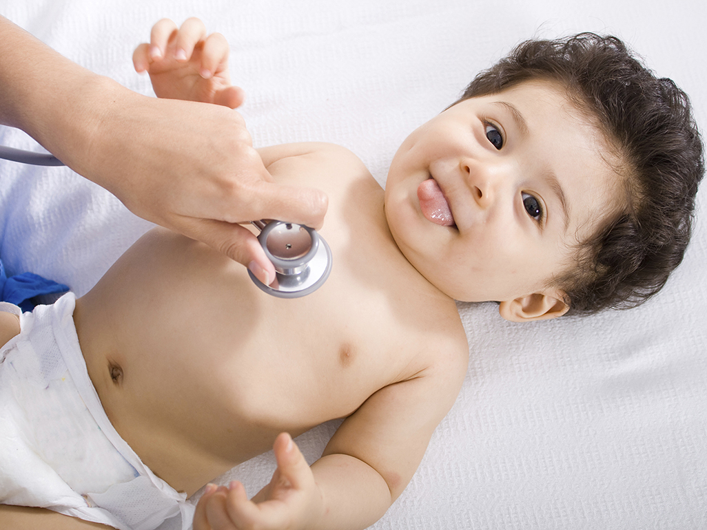 happy baby lying on examination table at doctor's office