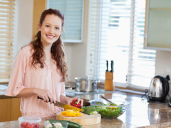 smiling woman cutting up vegetables