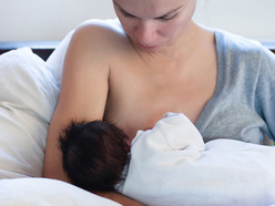 a mum preparing to breastfeed her newborn