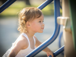 Preschooler climbing on play equipment