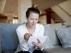 Woman sitting on the sofa looking at an iPad