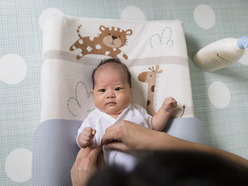 Baby lying on changing mat