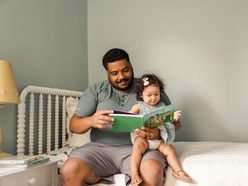 Dad reading book to daughter