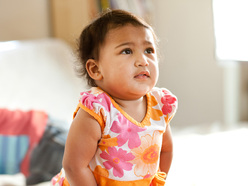 Toddler in an orange and pink floral dress