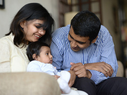 Mom and dad playing with their baby indoors