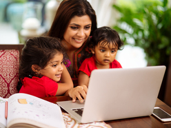 Mum looking at a computer with her children