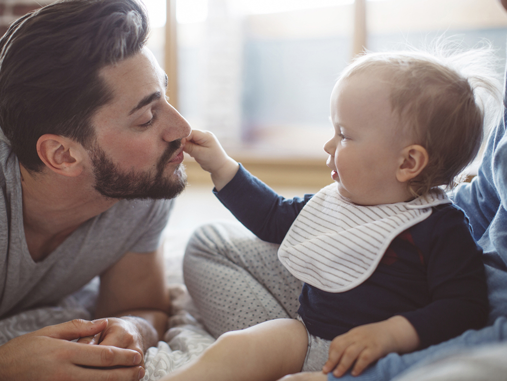 baby curiously pulling his father's beard