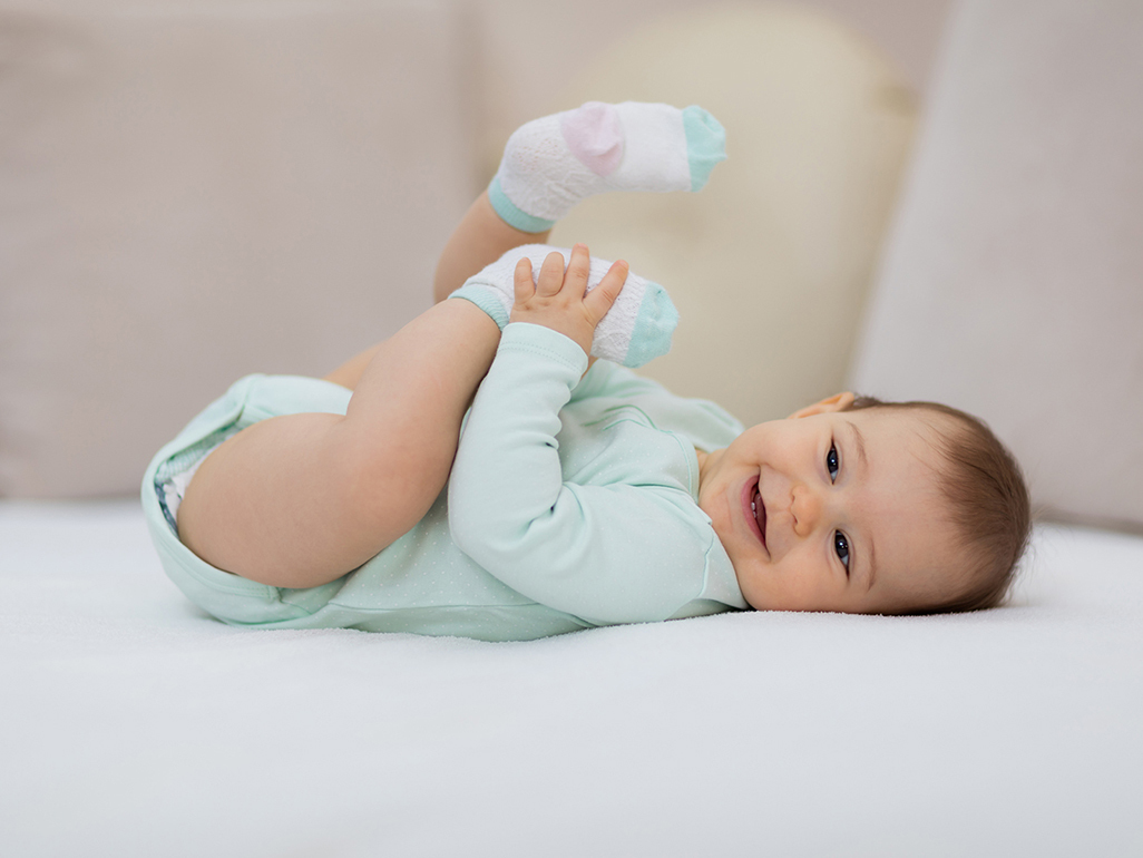 playful baby lying on a blanket