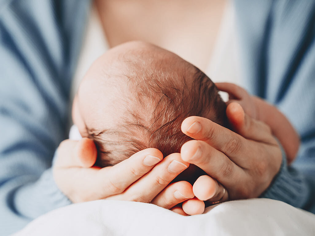 parent holding newborn baby's head