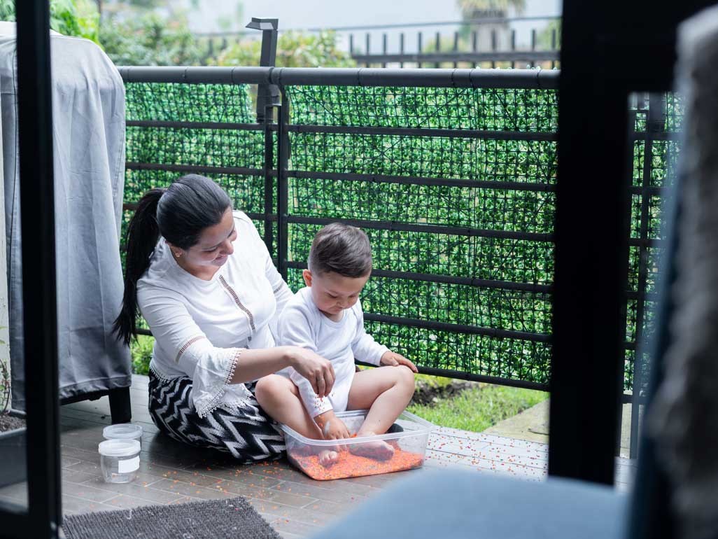 Woman doing sensory therapy with young boy