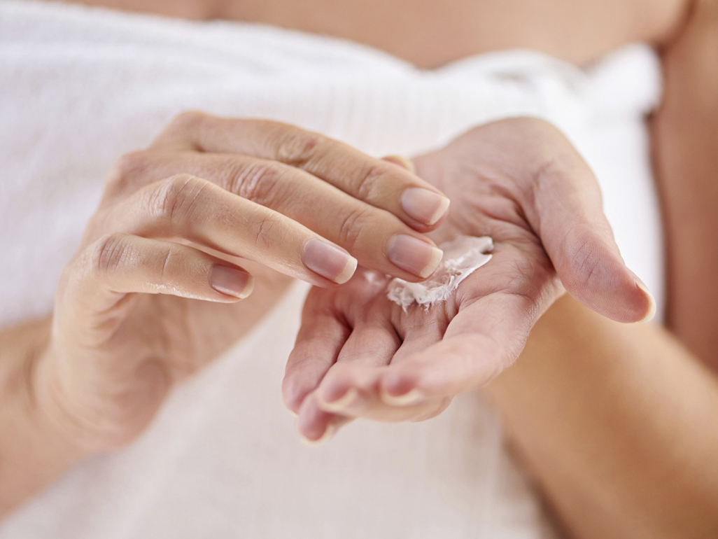 Woman putting on lotion