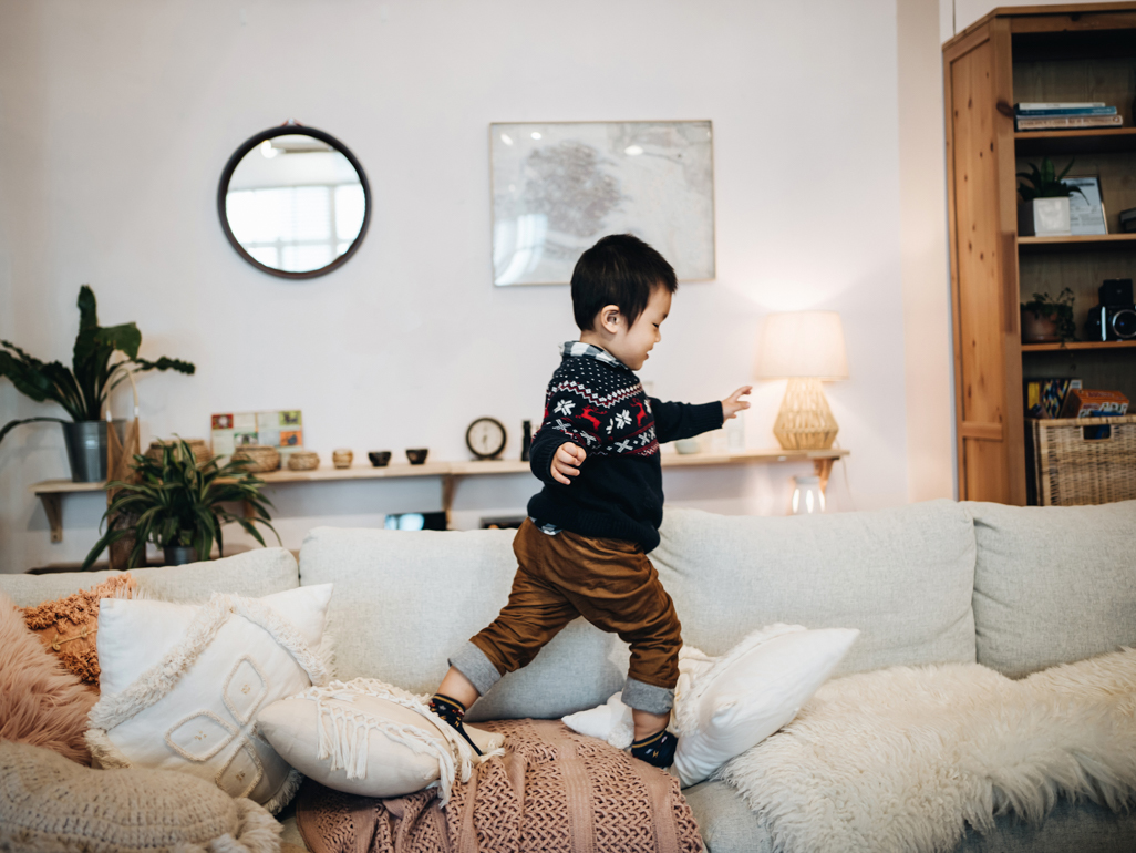 A toddler running across a couch