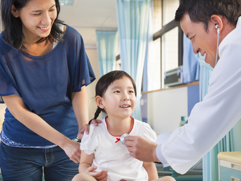 little girl with her mother getting examined by pediatrician