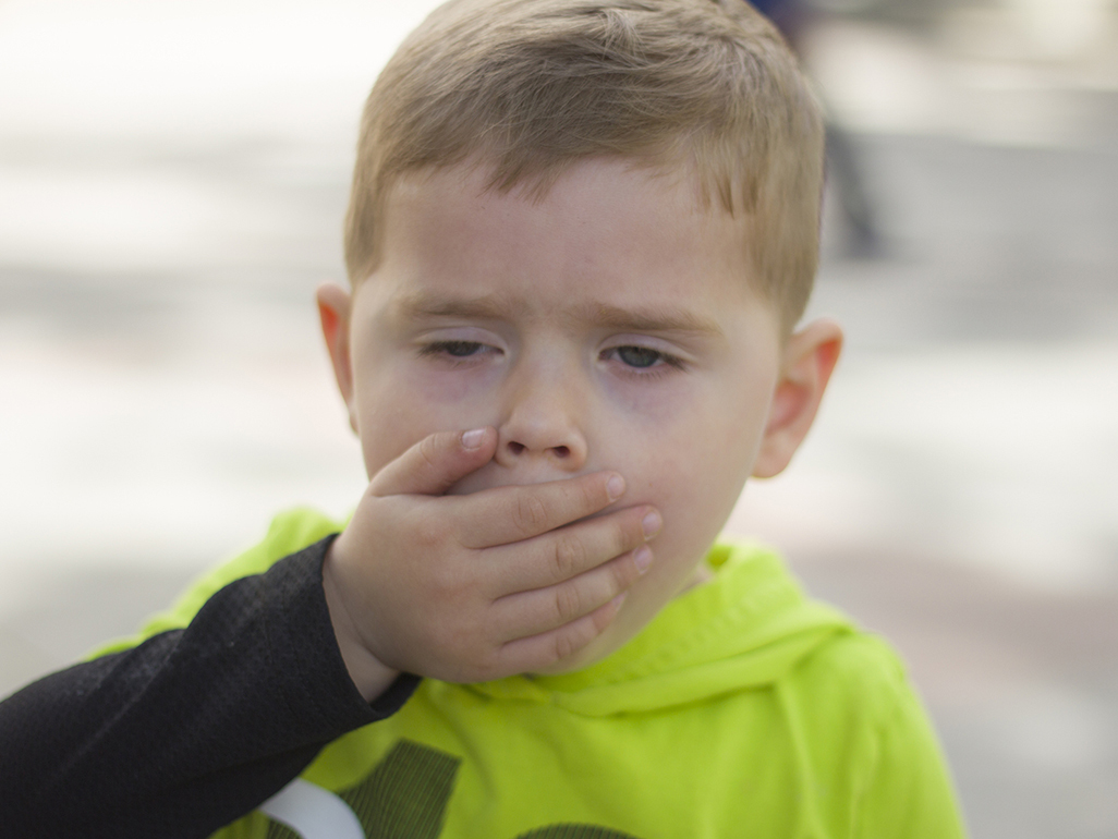 kid coughing into their hand