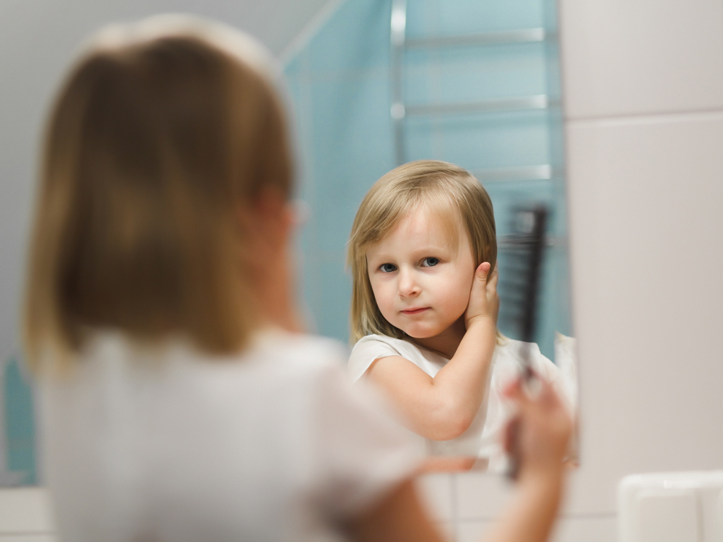 little girl holding her hair