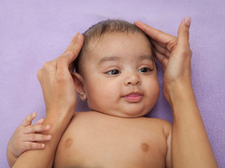 Mother massaging her baby's head