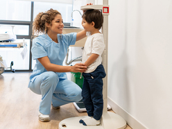 2 year old boy getting measured by a nurse